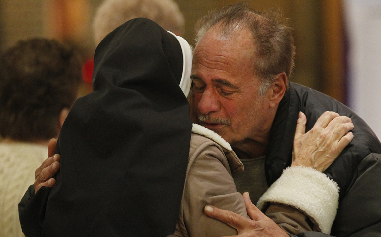 Dominican Sr. Jeanine Conlon embraces John Mennella following a Mass on Wednesday dedicated to people affected by Hurricane Sandy at St. Charles Church in New York's Staten Island. Mennella said he lost everything in his home during the monster storm that claimed the lives of three members of the parish. (CNS/Bob Roller)