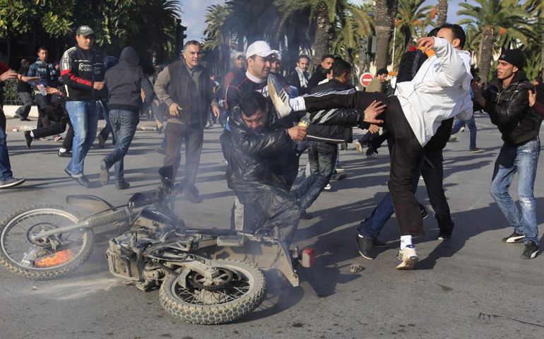 A protester kicks a policeman during clashes with riot police on Jan. 14, 2011, in downtown Tunis, Tunisia. (CNS/Reuters/Zohra Bensemra)