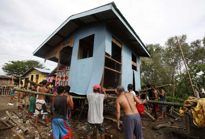 Residents lift a house damaged by Typhoon Rammasun, locally named Glenda, Thursday in a coastal village in Batangas, Philippines. (CNS/Reuters/Erik De Castro, Reuters) 