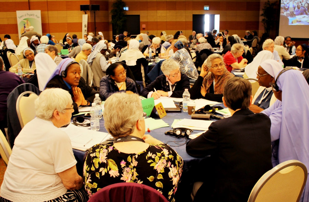 Sisters talk with their tables between presentations May 8 at the International Union of Superiors General's plenary assembly in Rome. (Courtesy of UISG)