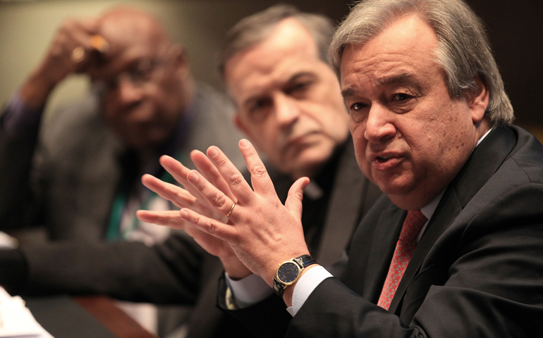 U.N. High Commissioner for Refugees Antonio Guterres gestures during a meeting Monday at the U.S. Conference of Catholic Bishops' headquarters in Washington. Looking on is Johnny Young, director of the USCCB's Migration and Refugee Services, and Auxiliary Bishop Eusebio Elizondo of Seattle, chairman of the bishops' Committee on Migration. (CNS/Bob Roller)