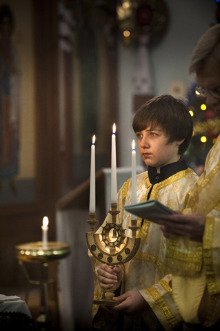 Altar server Andriy Palchak, 14, holds a candelabra a tradition known as the "Great Blessing of Water" during the Divine Liturgy celebrated for the feast of Theophany Jan. 12 at St. Mary's Assumption Ukrainian Catholic church in St. Louis. (CNS/St. Louis Review/Lisa Johnston)