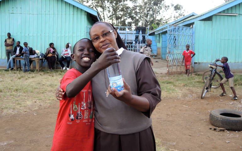 In the global south, religious life will change, too. Sr. Catherine Wanza holds a bottle of the Ukweli Oasis Drinking Water with Kennedy Mwaura, 15. The water bottling project is an income-generating project to help support school fees for more than 100 boys a year at the Ukweli Home of Hope for Street Boys, in northern Nairobi, Kenya, run by the Little Sisters of St. Francis of Assisi. (NCR photo/Melanie Lidman)