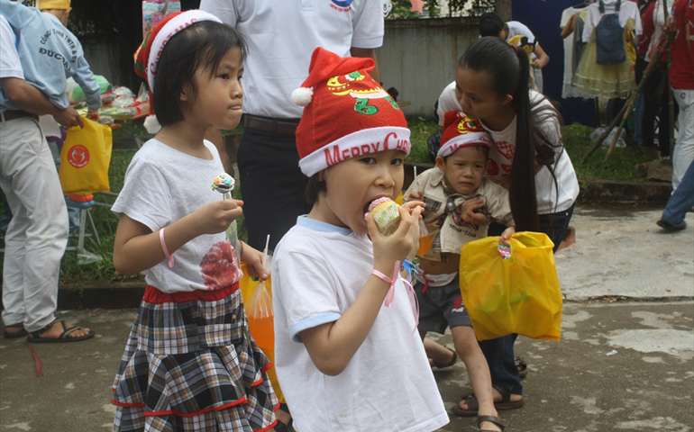 Children carry bags of goods they "bought" at the fair Dec. 15 at Holy Family Church in Nha Trang, Vietnam. (Joachim Pham)