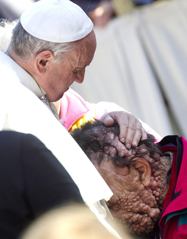 Pope Francis embraces Vinicio Riva, 53, during his Nov. 6, 2013, general audience in St. Peter's Square at the Vatican. (CNS/EPA/Claudio Peri)