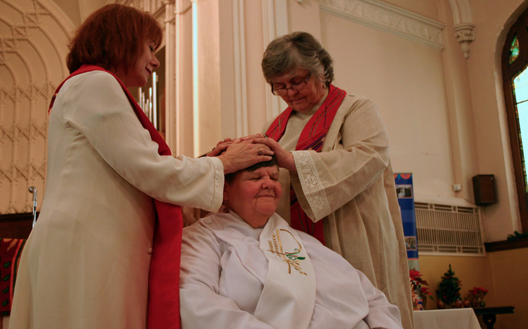 Women priests Janice Sevre-Duszynska, left, and Dotty Shugrue, right, bless Georgia Walker on Saturday at St. Mark Hope and Peace Lutheran Church in Kansas City, Mo. (Dawn Cherie Araujo)