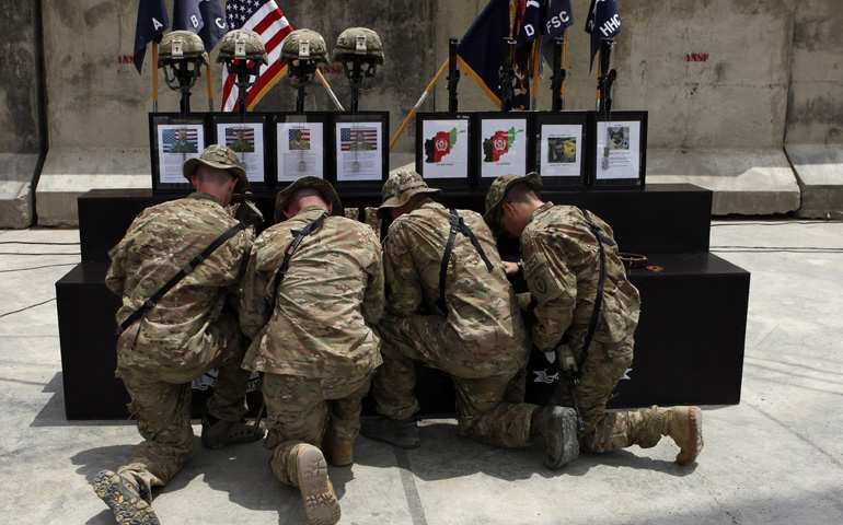 U.S. Army soldiers kneel during a memorial service in Forward Firebase Joyce in Kunar province, Afghanistan, in 2011. Four U.S. Army soldiers, two Afghan soldiers, an Afghan linguist and a military sniffer dog died during operations in Kunar district in the last week of June of that year. (CNS/Reuters/Baz Ratner)