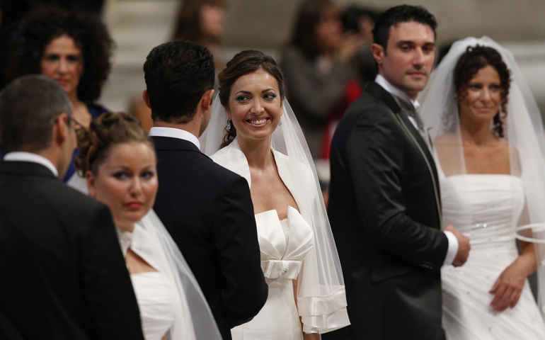 Newly married couples Marco Purcaro and Laura Capurso, center, and Fiorenzo Genito and Lidia Tortora, right, react after exchanging vows as Pope Francis celebrates the marriage rite for 20 couples during a Mass Sunday in St. Peter's Basilica at the Vatican. At left is Flaviano Picchi and Giulia Capozi, who are preparing to exchange vows. (CNS/Paul Haring)