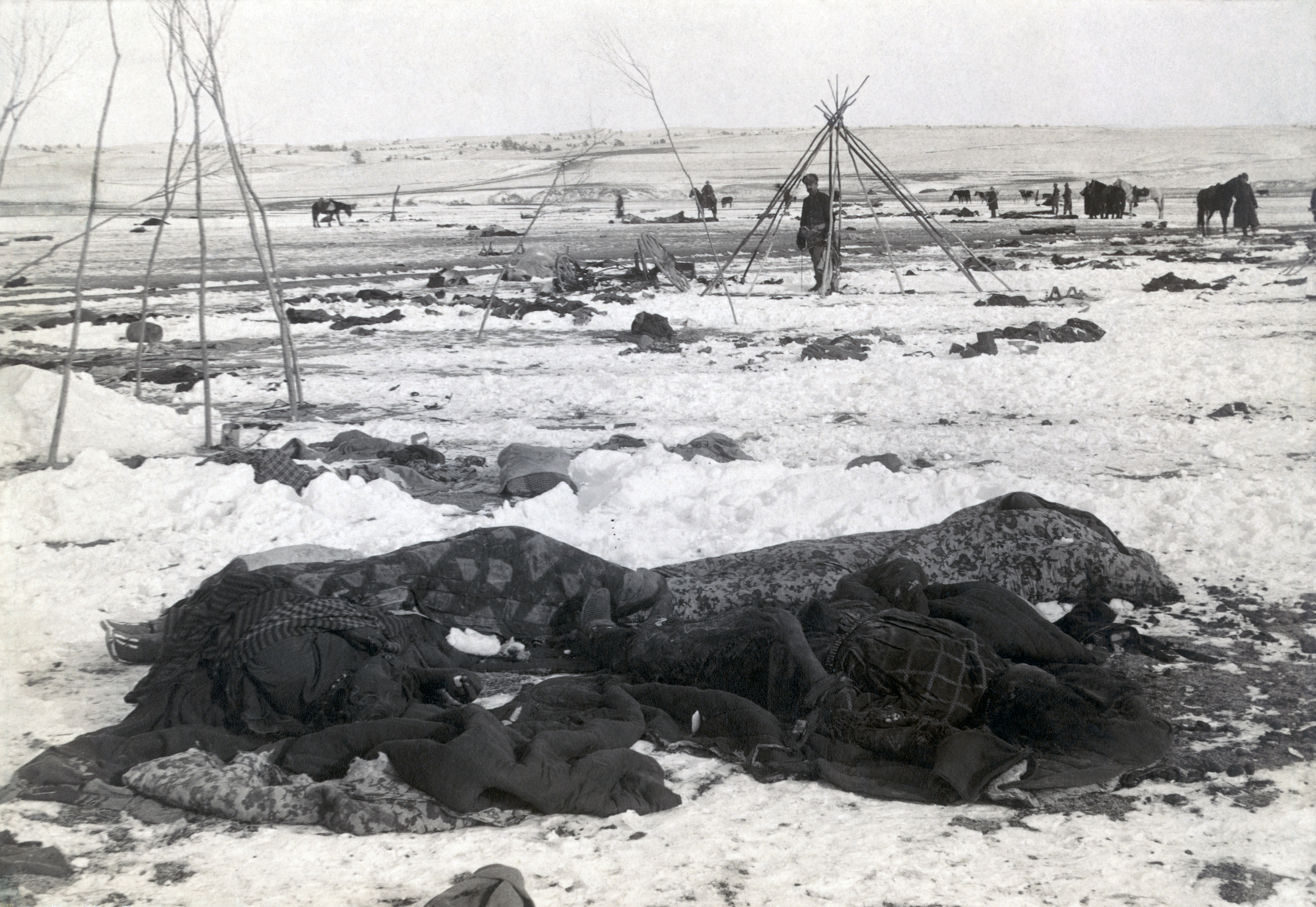 In January 1891, the bodies of four Lakota Sioux are seen wrapped in blankets, three weeks after the Dec. 29 massacre by U.S. forces at Wounded Knee River on the Pine Ridge reservation in South Dakota. (Library of Congress)