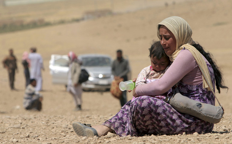 A displaced woman and child flee violence from forces loyal to the Islamic State in Sinjar, Iraq, Aug. 10. (CNS/Reuters/Rodi Said)