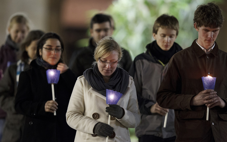 Young people carry candles as they participate in a Taize prayer service with Pope Benedict XVI in St. Peter's Square at the Vatican Dec. 29. More than 40,000 European young adults on a pilgrimage with the Taize ecumenical community joined the pope for evening prayer. (CNS/Paul Haring)