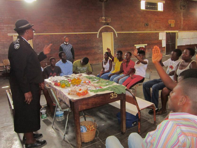 Gogo Wazara, a St. John Brigade commissioner, teaches her students what food people should eat and what food they can in the bush and roadsides to give their patients the balanced nutrition they need. She illustrates this with pictures or real samples. (Jill Day) 
