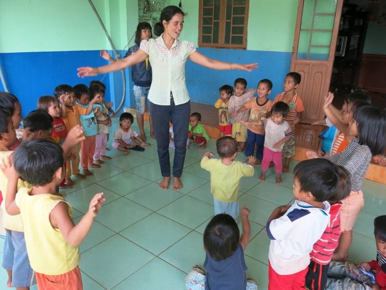 Ro Cham Hni, a teacher at the day care center, shows Jarai children how to perform a dance. (Joachim Pham)