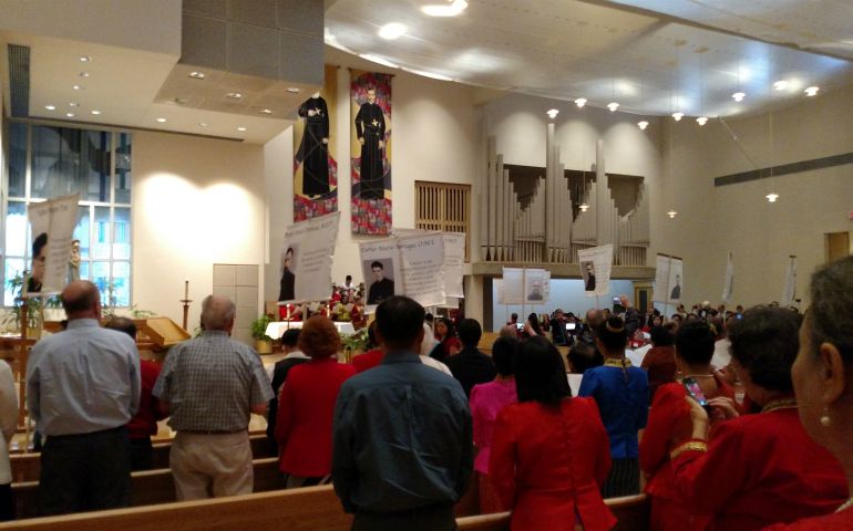 Celebrants paraded photos of the 17 martyr photos before the beginning of Mass celebration. (Peter Tran)