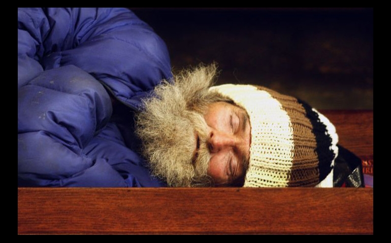 A man sleeps upon a pew in St. Boniface Church in San Francisco. (Jeanette Antal)