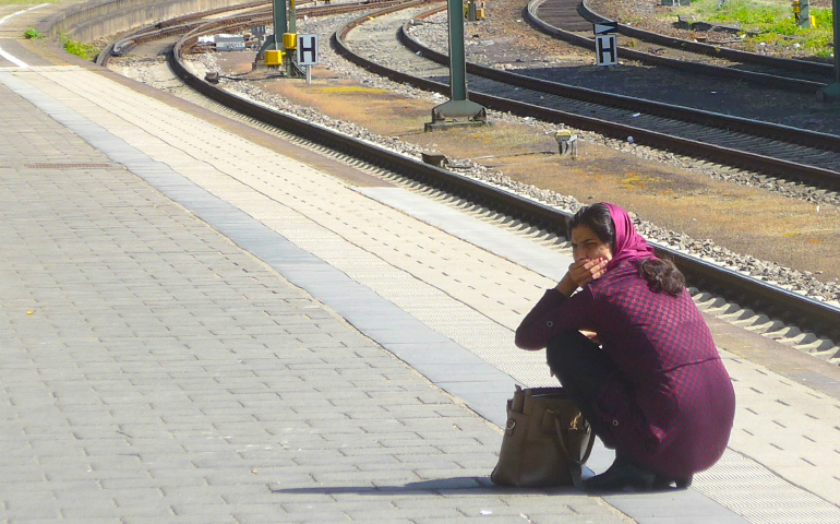A Muslim refugee woman waits for a train April 11 in Heidelberg, Germany. Amid rising social unrest and an influx of Mideast migrants, German authorities, including church officials, are facing criticisms from ordinary people who believe their concerns are being ignored. (CNS photo/Zita Fletcher)