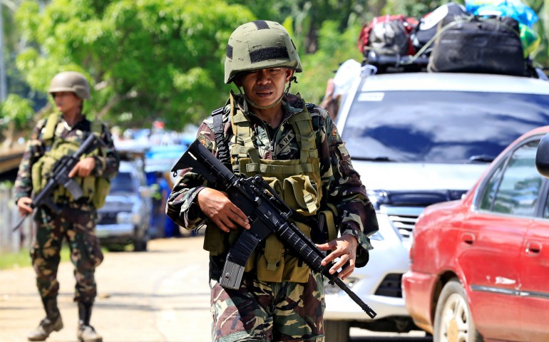 Philippine government troops stand guard May 24 at a checkpoint along a main highway in Lanao del Norte province. Residents started to evacuate the town of Marawi after President Rodrigo Duterte imposed martial law across the entire Muslim-majority region of Mindanao. (CNS photo/Romeo Ranoco, Reuters)