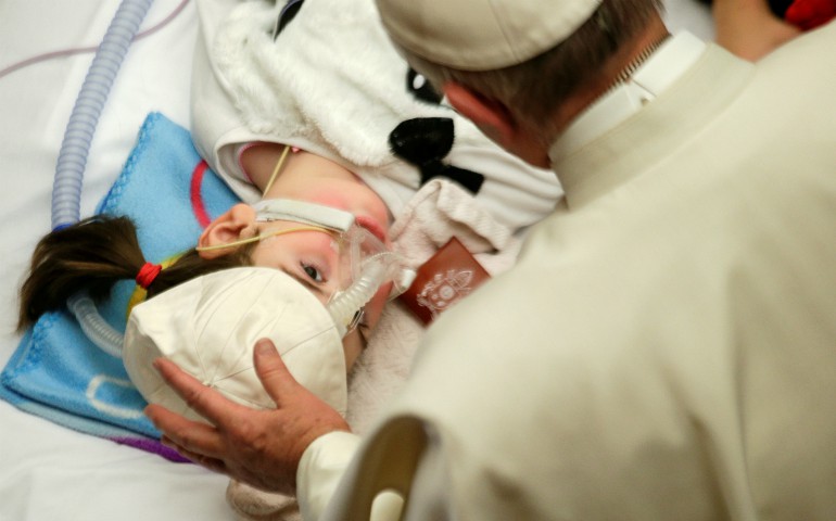 Pope Francis blesses a sick child in Paul VI hall at the Vatican Dec. 15, 2016, during a meeting with patients and workers of Rome's Bambino Gesu children's hospital. (CNS photo/Max Rossi, Reuters)