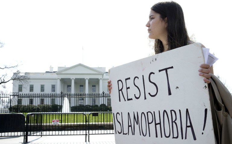 A peace activist holds a sign saying "Resist Islamophobia!" during a prayer service in early March outside the White House in Washington. (CNS/Tyler Orsburn)