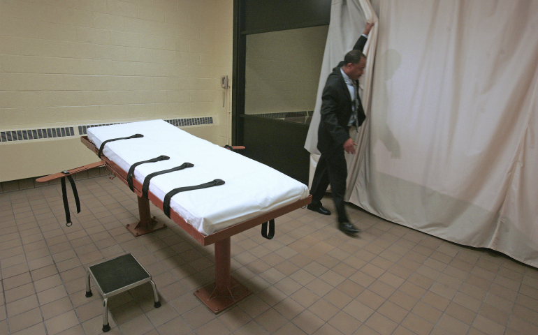 In this November 2005 file photo, Larry Greene, public information director of the Southern Ohio Correctional Facility, demonstrates how a curtain is pulled between the death chamber and witness room at the prison in Lucasville, Ohio. (AP photo/Kiichiro Sato)