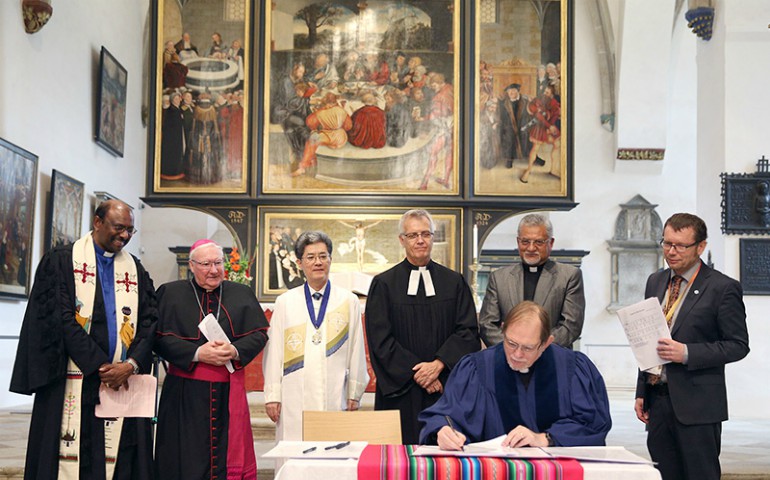 Reformed, Catholic, Lutheran and Methodist leaders look on as the Rev. Chris Ferguson, World Communion of Reformed Churches general secretary, signs the declaration expressing Reformed churches' support for the Catholic-Lutheran Joint Declaration on the Doctrine of Justification. (WCRC/Anna Siggelkow)