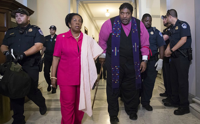 North Carolina NAACP President Rev. William Barber, accompanied by Rep. Sheila Jackson Lee, Texas, left, as activists, many of them clergy, are taken into custody by U.S. Capitol Police on Capitol Hill in Washington, D.C., on July 13, 2017. (AP Photo/J. Scott Applewhite)