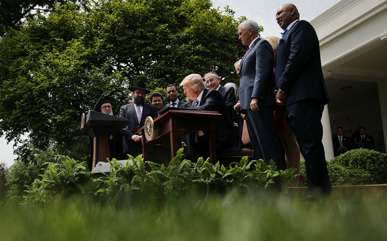 President Trump signs an Executive Order on Promoting Free Speech and Religious Liberty during the National Day of Prayer event at the Rose Garden of the White House in Washington, D.C., on May 4, 2017. (Reuters/Carlos Barria)
