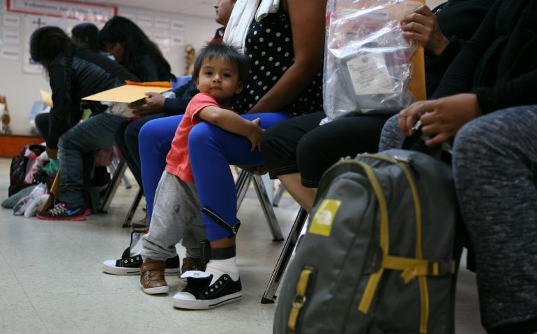 An 11-month-old Honduran child clings to his mother at the Humanitarian Respite Center in McAllen, Texas. Shelter volunteers were on hand to help immigrants just released from Border Patrol or ICE custody get transportation to other parts to the United States. (Nuri Vallbona)