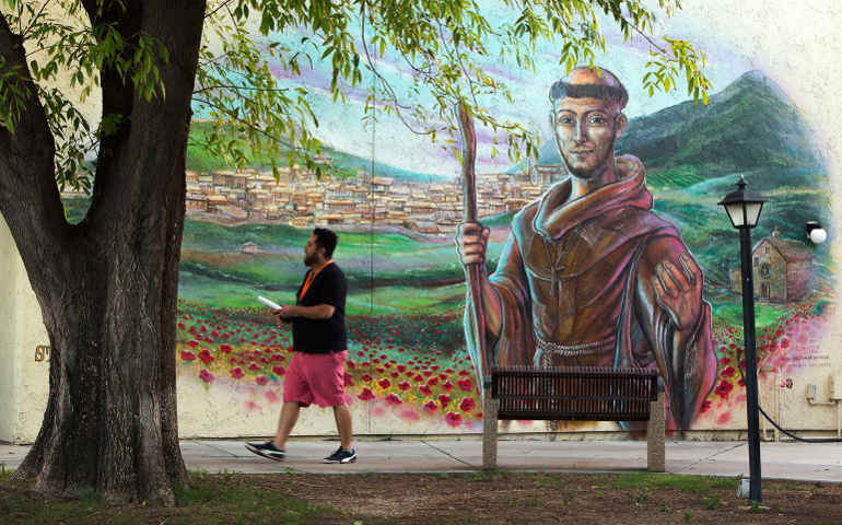 A man walks past a mural of St. Francis of Assisi at the Franciscan Renewal Center in Scottsdale, Ariz. (CNS file photo)