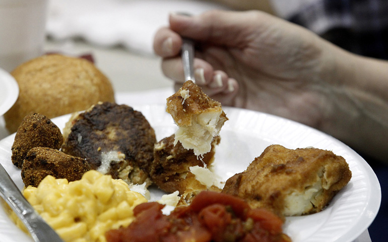 A fish fry guest eats fried haddock and other items Feb. 16, 2013, in the parish hall of St. Mary's Church in Altoona, Pa. (CNS/Bob Roller)