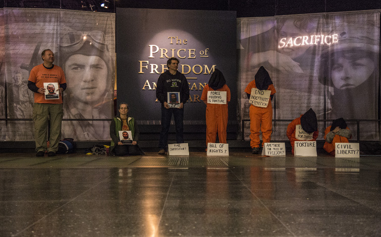 Carmen Trotta, center, with Witness Against Torture activists in a living Guantanamo exhibit Jan. 11 at the National Museum of American History, Washington, D.C. (Photo courtesy Witness Against Torture)