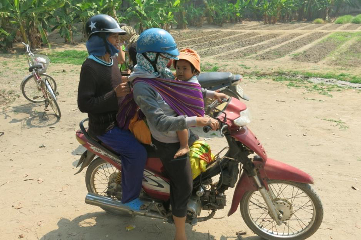 I'hon, left, heads home on a motorcycle driven by her daughter after the food exchange at the convent. (GSR/Joachim Pham)