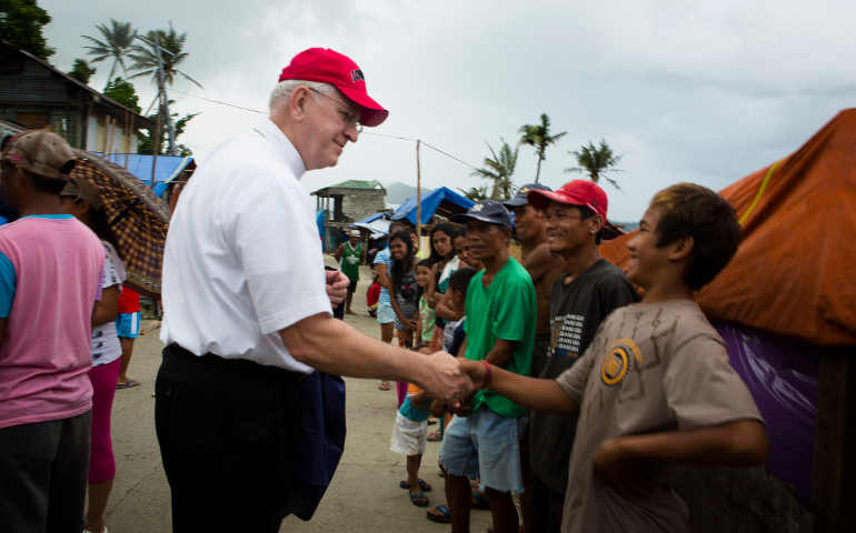 Archbishop Joseph E. Kurtz visiting Anibong, one of the communities in the Philippines affected by Typhoon Haiyan. Kurtz cited US church aid to these communities as “instructive” of how the bishops’ conference “is seeking to support people who are especially wounded and vulnerable.” (CNS/Tyler Orsburn)