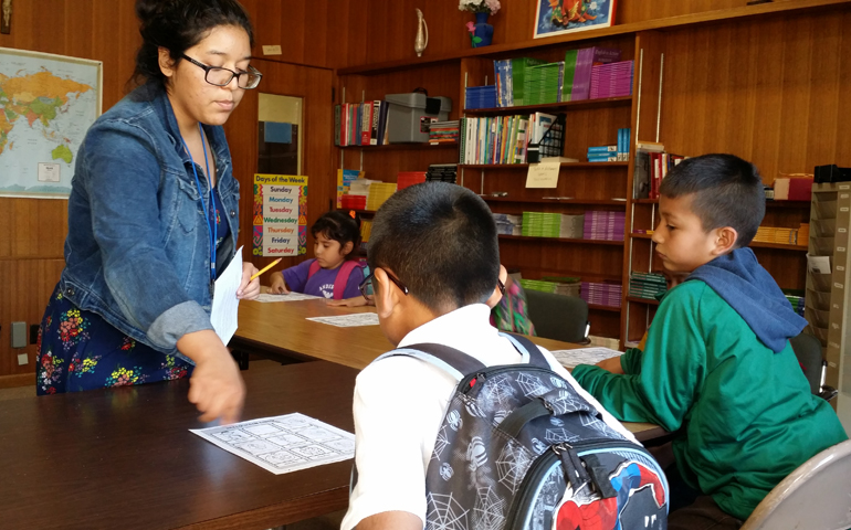 St. Joseph Worker Mariana Arriaza helps children in an afterschool program at Holy Rosary Church in Minneapolis in October 2015.