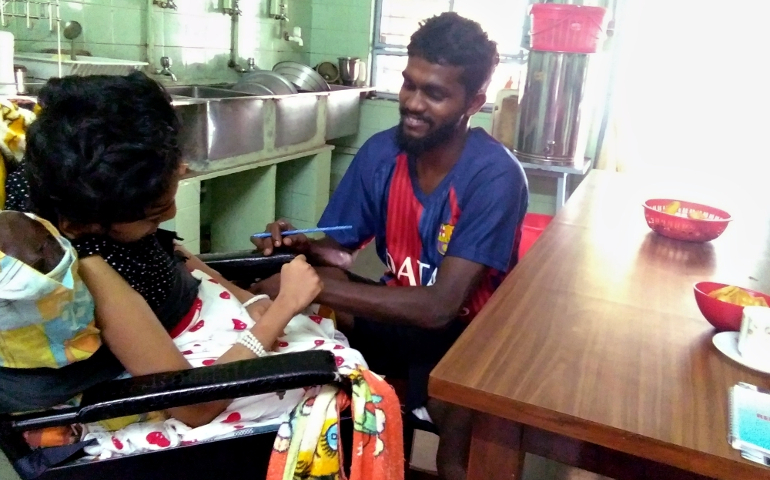 Alfred Palan, a young volunteer, helps a girl in the kitchen of the Marian House of Charity at Versova, a suburb of Mumbai, western India. (Lissy Maruthanakuzhy)