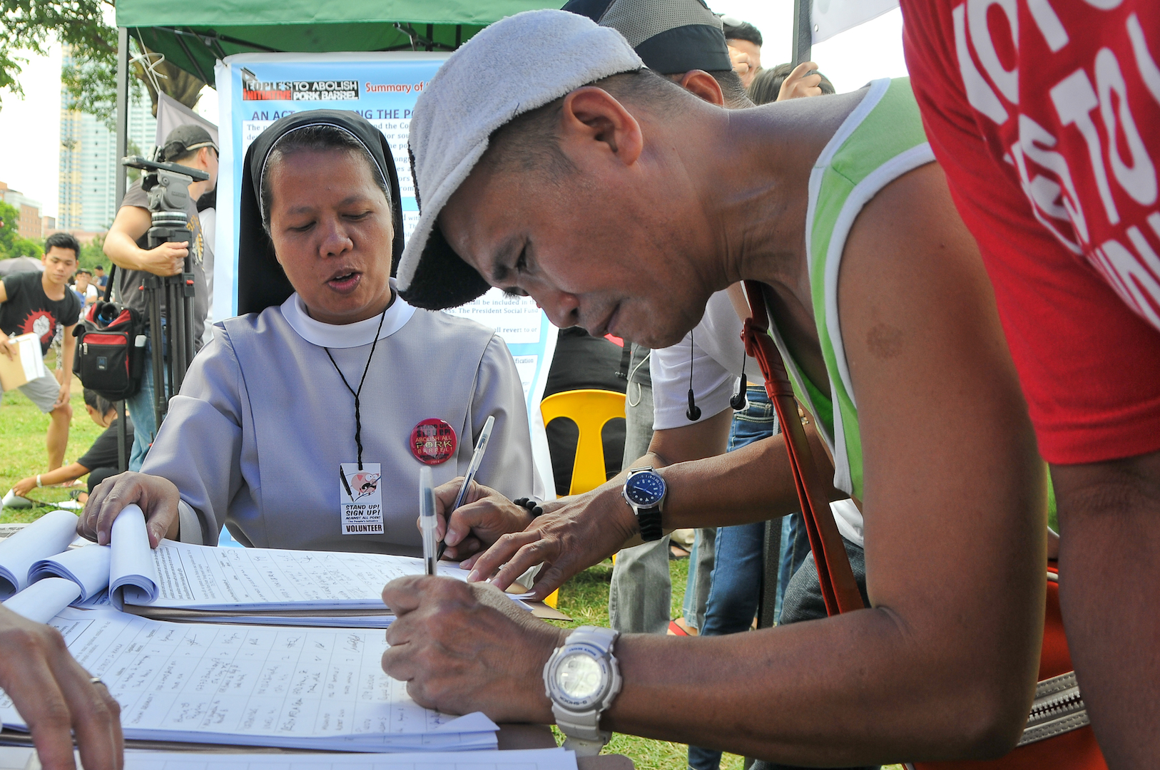 A Catholic nun helps voters sign up for the people's initiative to draft a law scrapping all lump sum discretionary funds Monday at Luneta Park, Manila, Philippines. (Roy Lagarde)
