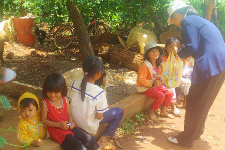 Ethnic children are happy to get sweets from a visiting sister. (GSR photo)