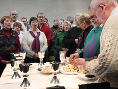 The congregation sings as Fr. Robert Marrone and Alan Klonowski break consecrated bread for Communion at the Community of St. Peter Feb. 12 in Cleveland. (Photos by Peggy Turbett)