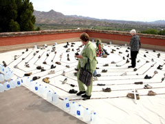 Two participants at the "Eucharist Without Borders" conference walk in a labyrinth made by artist Deborah McCullough. The labyrinth includes shoes migrants left while traversing the border. (Courtesy of Leo Guardado)