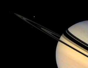 Saturn's rings shine dimly in scattered sunlight. One of Saturn's moons, Tethys, is visible in this view, acquired by the Cassini spacecraft's wide angle camera. (NASA)