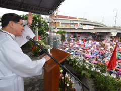 Thousands listen to Archbishop Luis Antonio Tagle in the rain at the Mary Queen of Peace Shrine in Quezon City, the Philippines, during a prayer rally against a proposed reproductive health bill. (Noli Yamsuan)