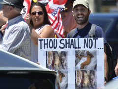 A man holds a poster showing photos of what he said were children killed in U.S. drone attacks during a demonstration in Fresno, Calif., June 24. (AP photo/The Fresno Bee/John Walker)