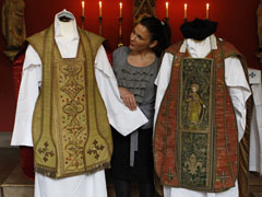 On Sept. 7, Katherine Milby from Abbotsford House in Scotland shows two vestments that were once owned by Cardinal John Henry Newman. (CNS/Reuters/David Moir)