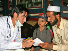 Dr. Syed Farooq Shah, left, treats patients as part of a Church World Service health clinic project in the village of Mohandari, near Balakot, northern Pakistan. (Photos by Chris Herlinger)