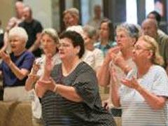 Parishioners pray using American Sign Language during Mass at St. Roman Catholic Church in Milwaukee July 16. (Newscom/MCT/Michael Sears)