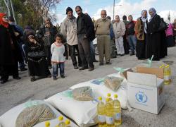 Palestinians wait to pick up food supplies from Catholic Relief Services in Al Ayzariyah, West Bank, Dec. 8. The agency's workers traveled a roundabout way from Bethlehem to deliver the much-needed food. Going the more direct route through Jerusalem would require a special Israeli travel permit. (CNS/Debbie Hill)
