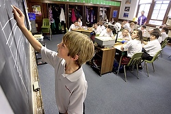 Sixth-grade student Brandon Miller does a math problem on the blackboard during class at Pope John Paul II School in Wilmington, Del., in April. (CNS photo/Don Blake, The Dialog)