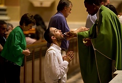 A man kneels to receive Communion during a weekday Mass at the Cathedral Basilica of Sts. Peter and Paul in Philadelphia in 2011. (CNS/Nancy Phelan Wiechec)