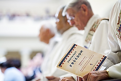 A member of the clergy holds a program during the opening Mass for the U.S. bishops' Fortnight for Freedom campaign June 21 at the Basilica of the National Shrine of the Assumption of the Blessed Virgin Mary in Baltimore. (CNS/Catholic Review/Tom McCarthy Jr.)