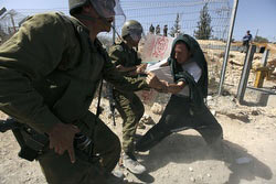 Israeli soldiers scuffle with a protester during a protest against the controversial Israeli barrier in the West Bank village of Bilin near Ramallah Sept. 25. (CNS/Darren Whiteside, Reuters)